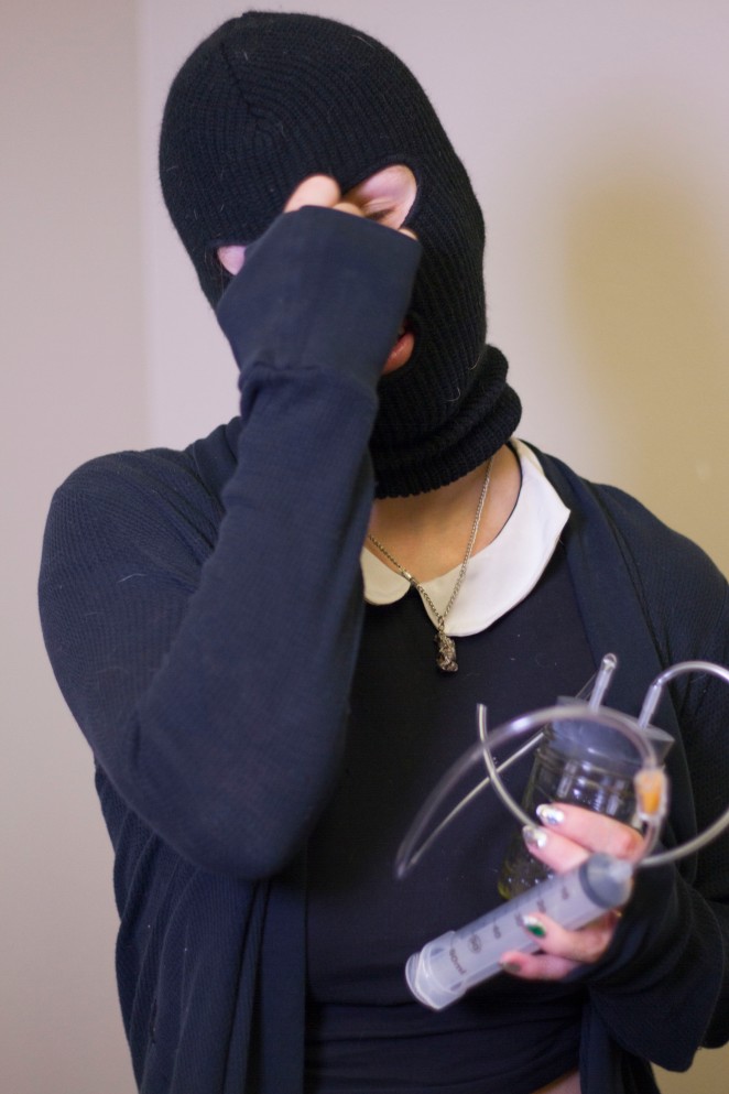 Because of the illegal nature of her work, Jane wears a ski mask to protect her identity. She is holding a menstrual extraction kit, which she makes using commonly found supplies. (Photo by Jose Olivares)
